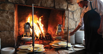 Cheese melting onto plates near fireplace
