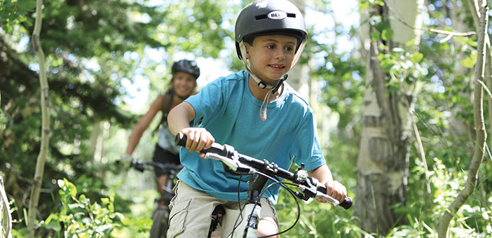 Woman and Child mountain biking on a forest trail