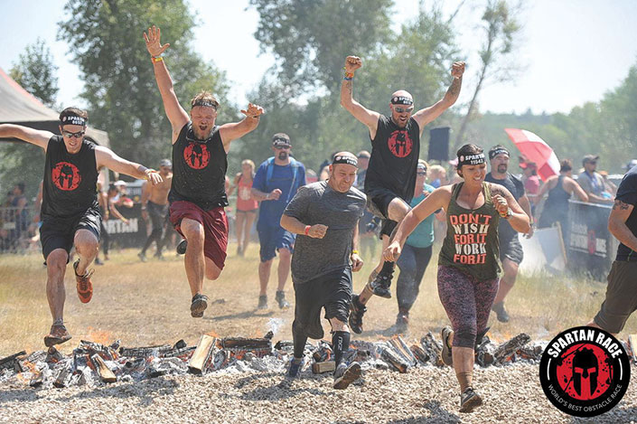 Author Nick Como leaping the fire at the Spartan finish line